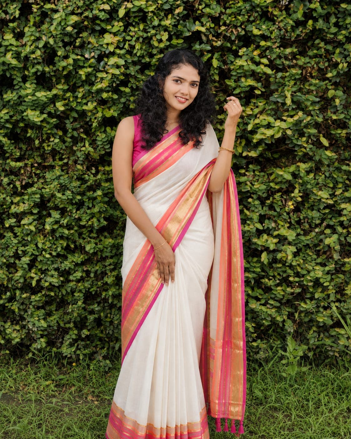 Lavender pink embroidered saree next to a green plant